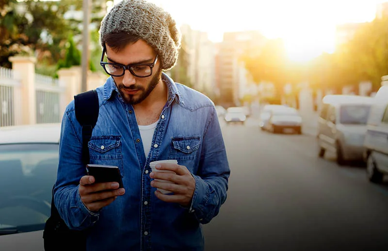Modern young man with mobile phone in the street.